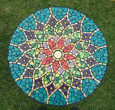 a colorful mosaic table sitting on top of green grass