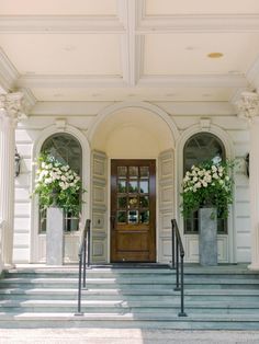 an entrance to a building with flowers on the steps