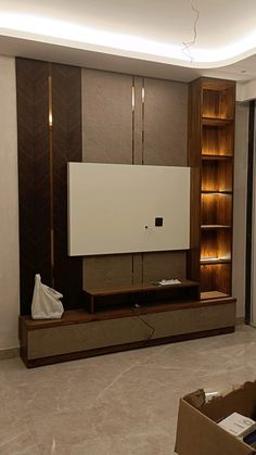 an empty living room with a flat screen tv on the wall and some bookshelves