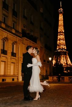 a newly married couple kissing in front of the eiffel tower