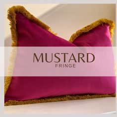 a pink and yellow pillow with the words mustardd fringe on it's side