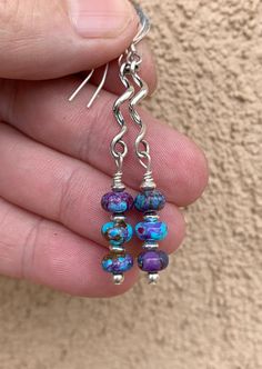 Gorgeous mix of blue and purple Mojave Kingman turquoise and bronze compressed into a rondell beaded earring. All sterling silver beads and the sterling silver twist is lightly antiqued. Southwestern style earrings. 1.75 inches in length. *6-7mm blue and purple Mojave Kingman turquoise and bronze rondelles  *Sterling silver, slightly antiqued twisted spirals *Sterling silver saucer beads and ear wires  *All earrings are packaged with a branded earring card and white organza pouch. *Clean and pol Artisan Polished Beads Earrings As Gift, Artisan Polished Beads Earrings For Gift, Artisan Earrings With Polished Beads For Gift, Bohemian Blue Earrings With Polished Beads, Blue Bohemian Earrings With Polished Beads, Artisan Sterling Silver Jewelry With Spacer Beads, Artisan Jewelry With Spacer Beads In Sterling Silver, Gift Turquoise Earrings With Polished Beads, Unique Sterling Silver Earrings With Round Beads