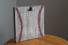 a wooden box with a baseball stitched on the side and a metal hook attached to it