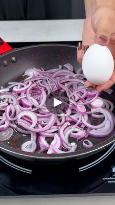 someone is frying onions in a pan with an egg on the stove burner