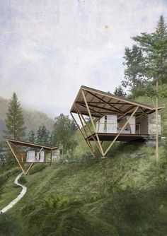 two wooden structures sitting on top of a lush green hillside covered in trees and grass