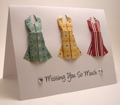 three origami dresses on a card that says missing you so much