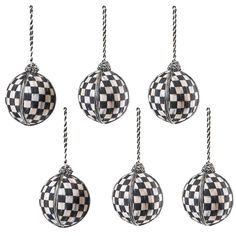 four ornaments hanging from twine with black and white checkerboard pattern on them