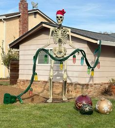 a skeleton is watering the yard in front of a house