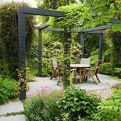 an outdoor dining area in the middle of a garden