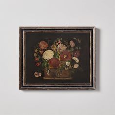 a painting with flowers in a vase hanging on the wall next to a white wall