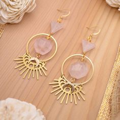 Every now and then you need a little Rose Quartz in your life. ;) Talk about the perfect statement earrings! These babies sparkle with every move you make. Gleaming with gold and the perfect shade of pink that can only be created by natural rose quartz gemstones. Attract tons of compliments with our gorgeous Eclipse of the Heart Earrings handmade with faceted, hexagon rose quartz gems, rose quartz triangles, and 18k gold plated moon burst eclipse charms. Experience a little bit of passion with e Pink Heart Gemstone Earrings, Pink Heart-shaped Gemstone Earrings, Handmade Blush Jewelry For Gifts, Pink Brass Earrings As Gift, Pink Brass Earrings For Gifts, Pink Gemstone Earrings For Valentine's Day, Pink Rose Quartz Jewelry For Party, Pink Rose Quartz Party Jewelry, Pink Rose Quartz Jewelry With Matching Earrings