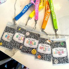 four lanyards with name tags attached to them sitting on a table next to each other