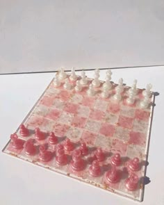 a glass chess board with red and white pieces