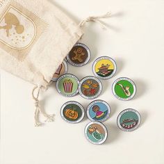 several badges are placed next to a drawstring bag