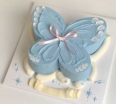 a blue butterfly cake sitting on top of a white plate