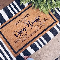 a welcome mat with the words open house on it next to a potted plant