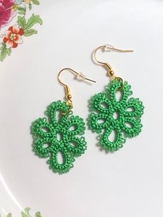 green crochet earrings on a white plate