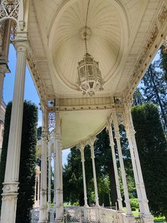 an ornate white gazebo in the middle of a park