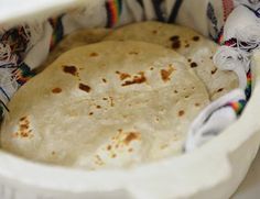 two tortillas in a white bowl on a table