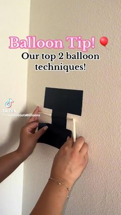 someone is holding a black piece of paper in front of a wall with the words balloon tip on it