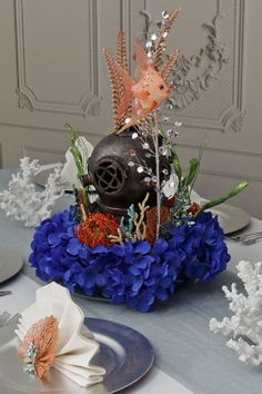 a table topped with blue flowers and plates