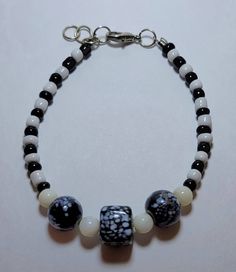 This is a beautiful black and white bracelet with 3 stunning glass focal beads. Fastened with a lobster claw clasp and chain.  Measures: 20cm minimum  I can add chain for desired length White Beaded Bracelet, White Beads Bracelet, White Bracelet, Focal Beads, White Bracelets, Focal Bead, White Beads, Lobster Claw, Beaded Bracelet