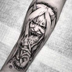 a black and white tattoo with an evil face holding a knife in it's hand