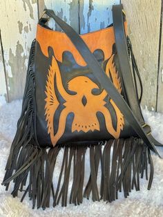 Embrace your free-spirited style with our Wild Wanderer Fringed Leather Crossbody Boho Bag. Handcrafted from genuine leather, this bohemian bag features playful fringe details that add a touch of boho to your outfit. Perfect for festivals, concerts, or everyday use, this crossbody bag will become your go-to accessory for a carefree and adventurous lifestyle. Handcrafted Genuine Leather Fully Lined in Black Zip Close Colour -Black with Tan feature Internal - 1 large Zip Pocket, 1 open pockets One zip pocket on back of bag also Measurements : Approx: Width 27cm, Height Approx: 31cm Adjustable strap for shoulder or crossbody wear Please keep in mind that leather is a natural product and colour variations & marks in the hide are not considered faults but make each piece unique & individual. Leather Hobo Bag Crossbody For Festival, Leather Crossbody Hobo Bag For Festivals, Black Bohemian Shoulder Bag With Tassels, Black Bohemian Bag With Fringe, Bohemian Leather Hobo Bag With Tassels, Leather Fringe Hobo Bag For Festivals, Bohemian Leather Hobo Bag In Crossbody Style, Bohemian Leather Bag With Tassels, Bohemian Leather Crossbody Hobo Bag