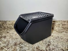 a black trash can sitting on top of a counter