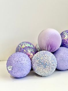 purple and silver ornaments are stacked on top of each other in the shape of balls