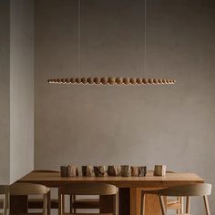 a dining room table with chairs and lights hanging from the ceiling