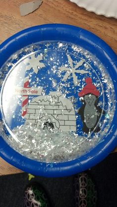 a paper plate with an image of a penguin on it in the middle of some water