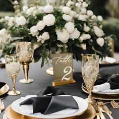 the table is set with black and gold place settings