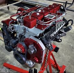 a red engine sitting on top of a stand