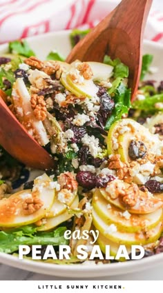 a salad with pears, blue cheese and walnuts in it is served on a white plate