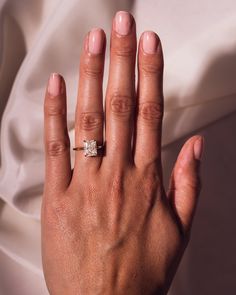 a woman's hand with a diamond ring on it