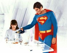 a man in a superman costume pouring wine at a table