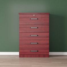 an empty room with green walls and a wooden dresser in the corner, next to a hardwood floor