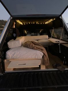 there is a bed in the back of a truck with lights on it's sides