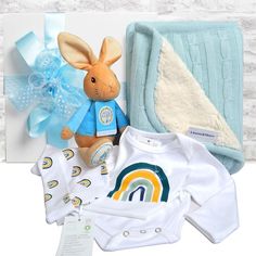 a baby's gift set includes a blanket, bodysuit, and toy rabbit