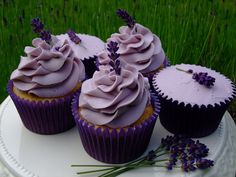 four cupcakes with frosting and lavender sprinkles on a plate