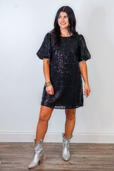 Black sequin dress with short puff sleeves This Chasing Midnight Black Sequin Dress is the perfect way to sparkle the night away! With her dazzling black sequin fabric and short puff sleeves, you'll be sure to make a statement. Just grab your heels or boots, and get ready to shimmer and shine! Shop these silver metallic boots that complete the look here! True to size fit; relaxed silhouette Model is 5'3" wearing a small Fabric does not contain stretch Crew neckline with hidden hook and eye zippe Silver Metallic Boots, Black Sequin Fabric, Queen Of Sparkles, Metallic Boots, Short Party Dress, Vintage Couture, Black Sequin Dress, Clothing Logo, Sequin Fabric