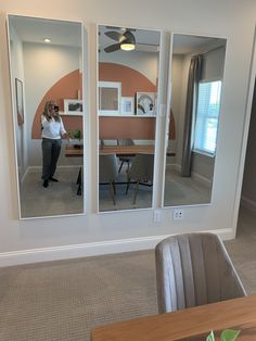 a woman is taking a photo in the reflection of two mirrors that are reflecting her office