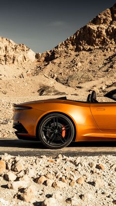 an orange sports car parked in the desert