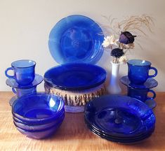 blue glass dishes and vases on a wooden table