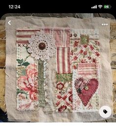 a piece of cloth with flowers, hearts and other things on it that are pinned together