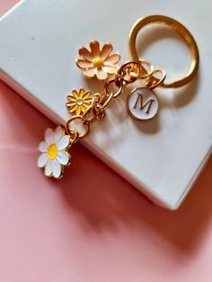 a gold key chain with flowers on it