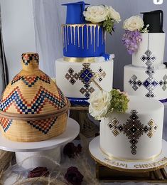 there are many cakes on the table with flowers in each tiers and one has a cross on it