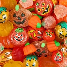 there are many candy candies with faces on them and pumpkins in the background