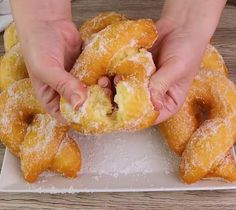 a person is grabbing some doughnuts from a plate